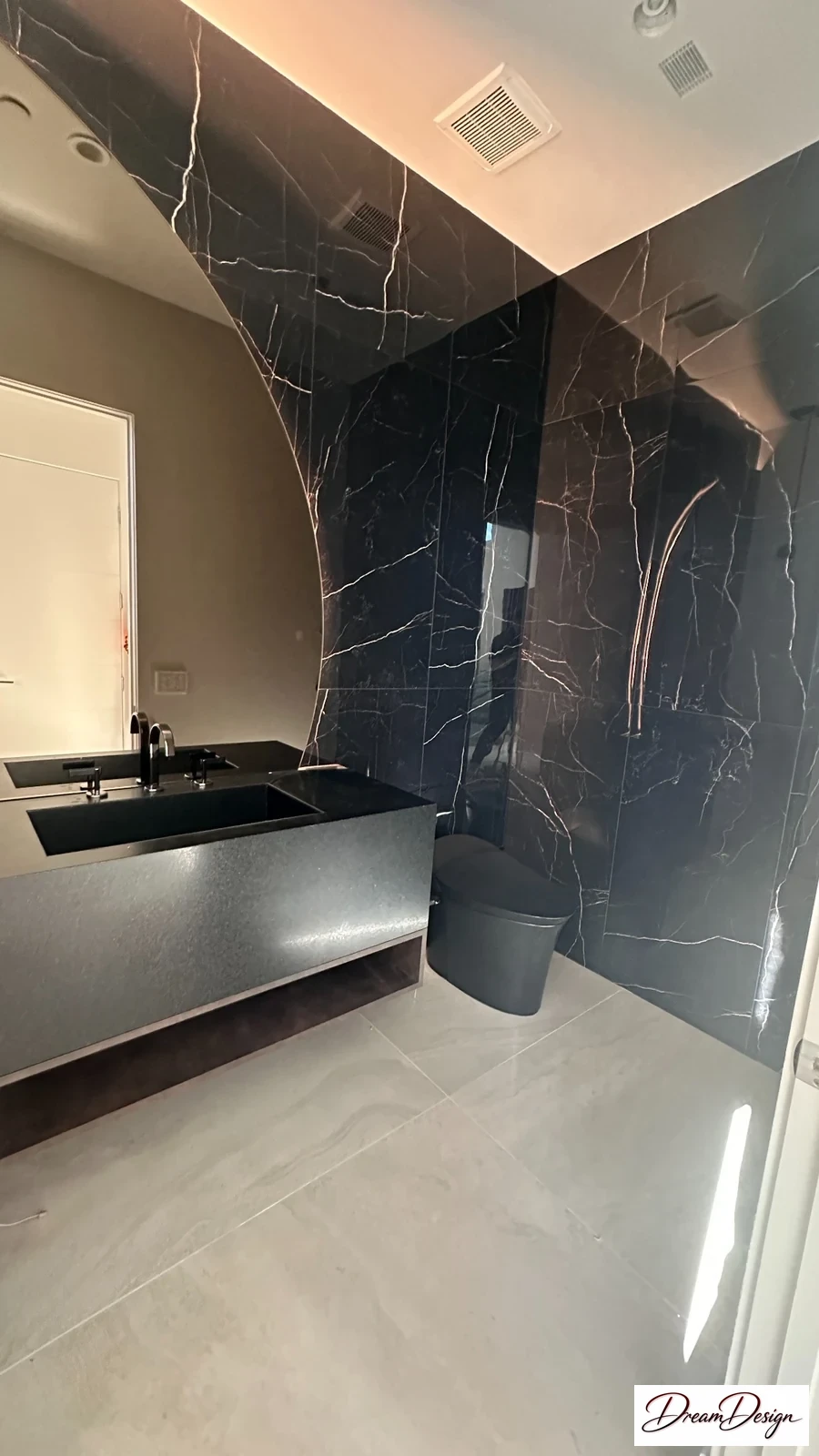 Dark veined wall panels above a floating vanity and pale floor.