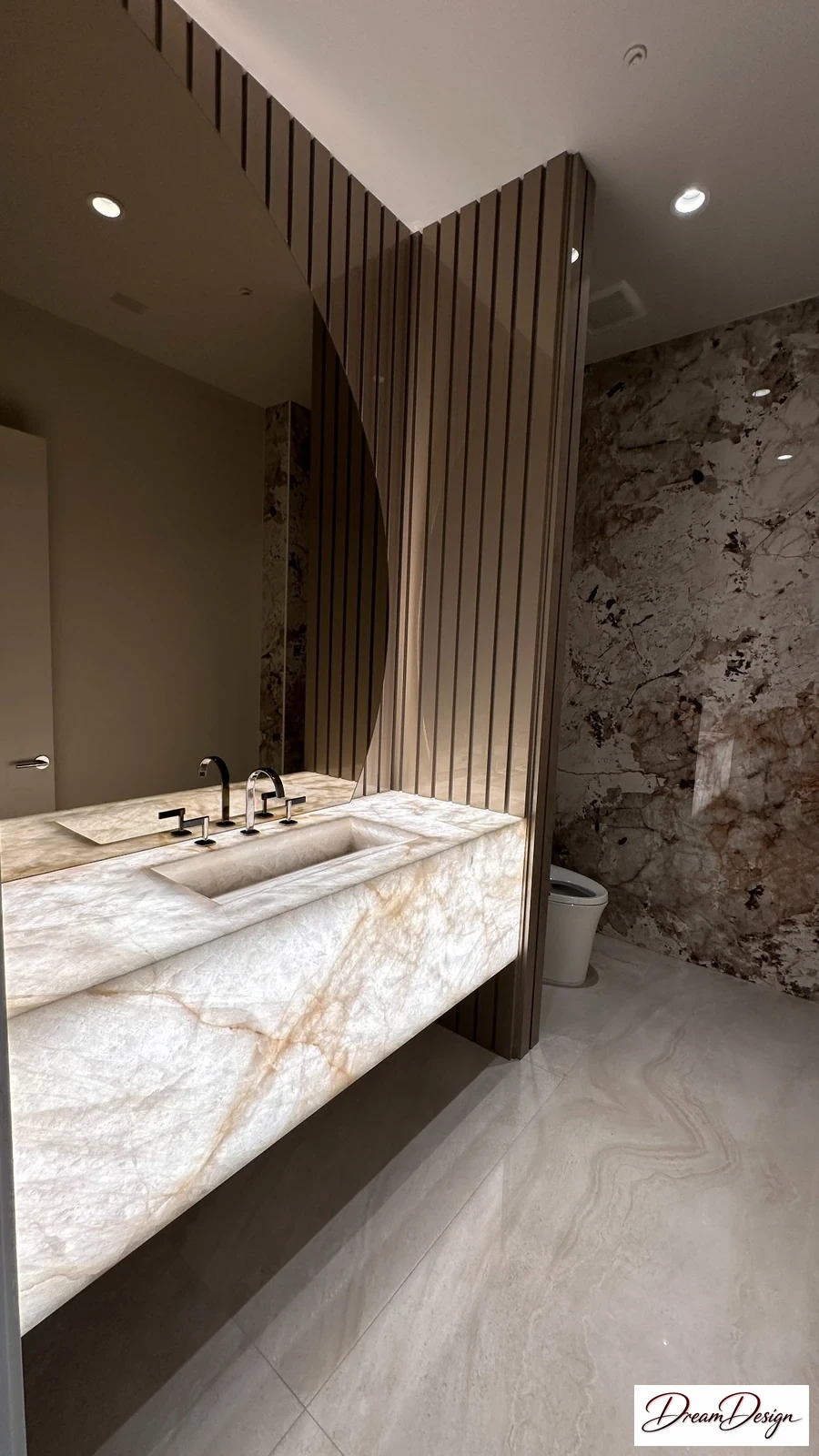Floating veined vanity, adjacent mirror panels and a vertical fluted wall in a powder room.