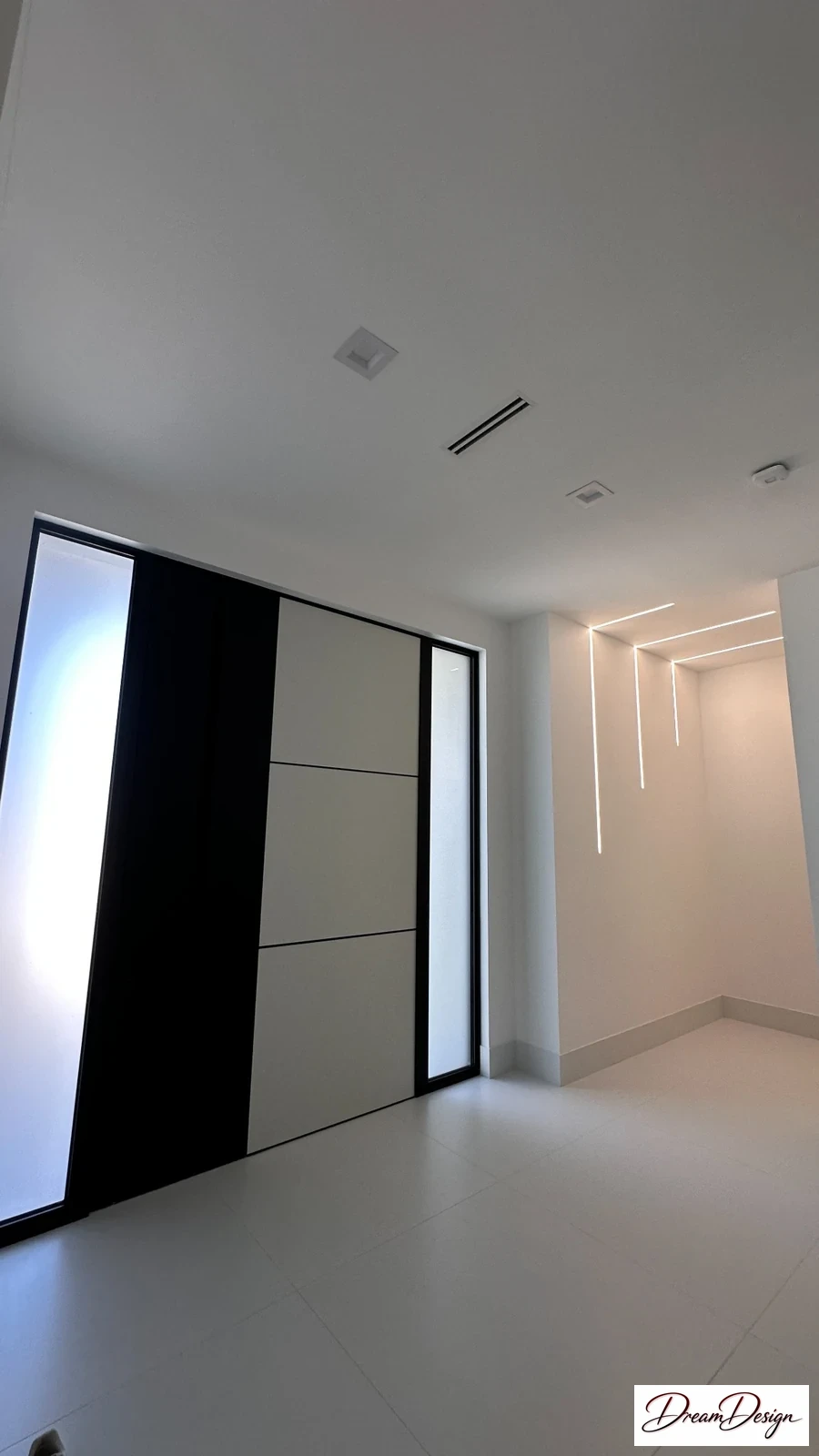 Full-height entry cabinetry with alternating light and dark panels beside a pale floor.