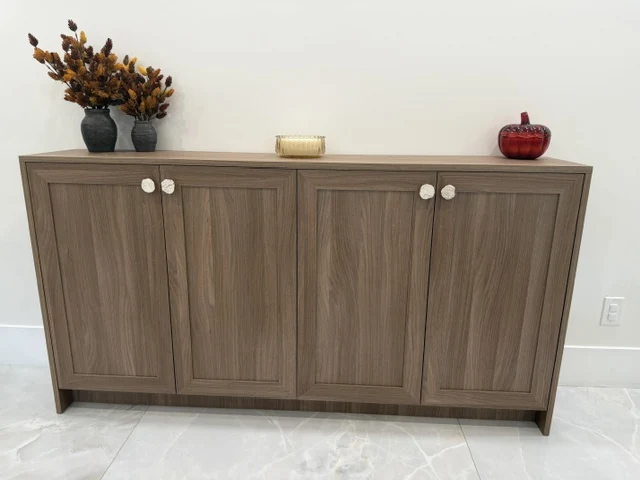 Wood-grain sideboard with four framed cabinet doors and round white knobs.